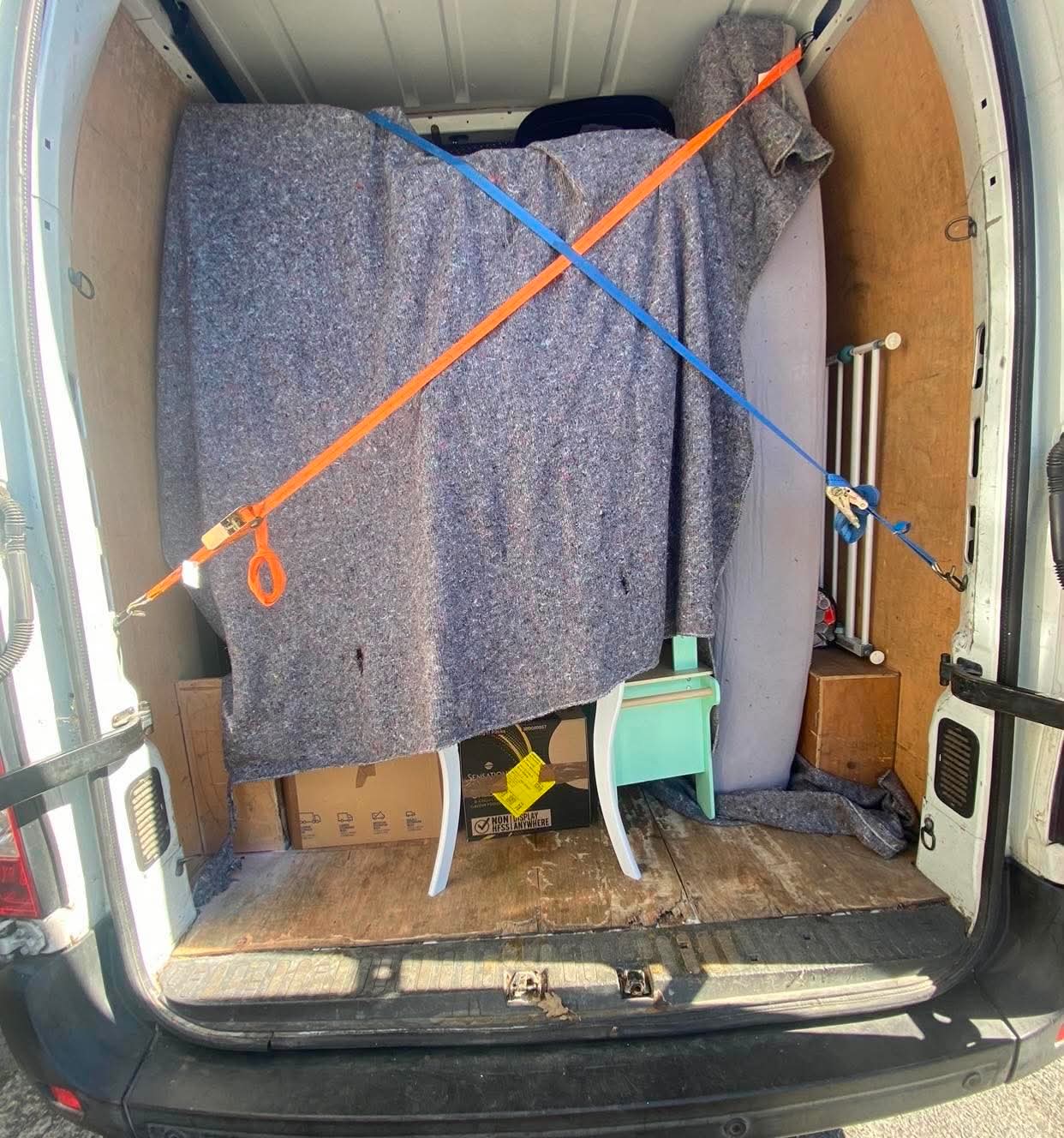 Loaded removal van with strapped and blanketed items